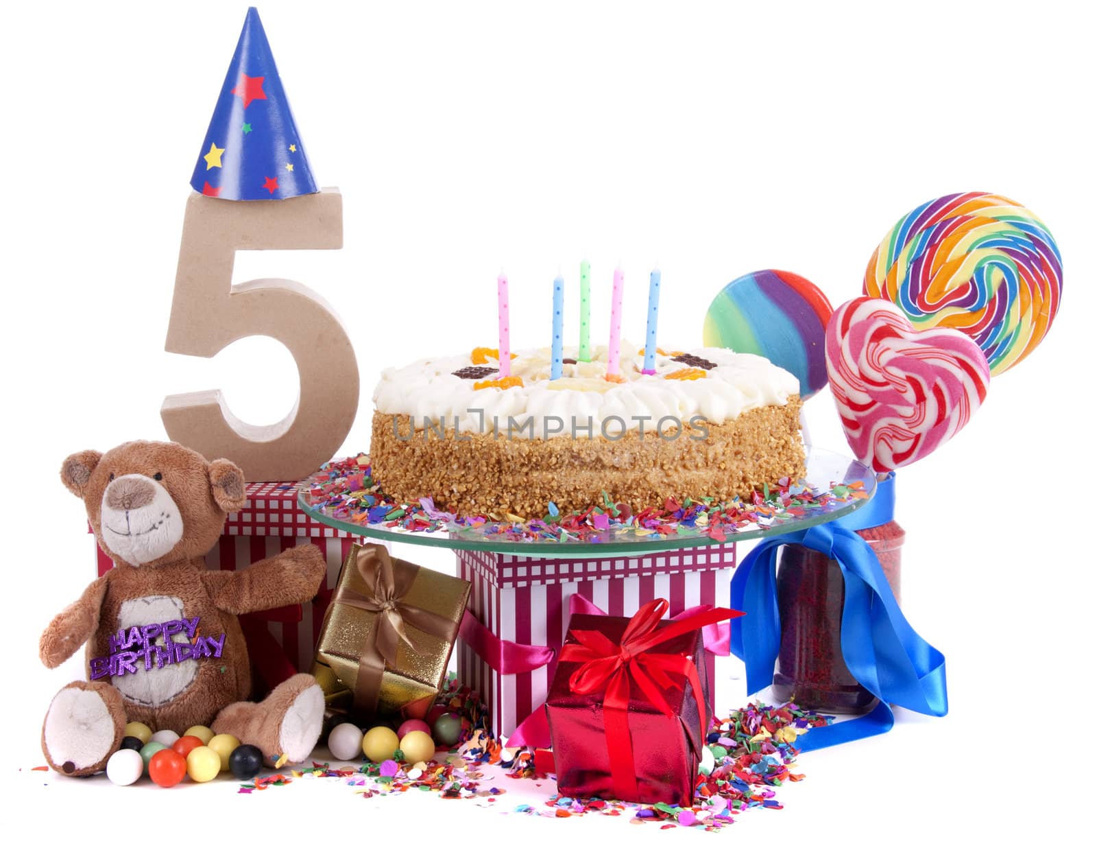 Number of age in a colorful studio setting with paper party hats, a red heart and gifts on a bottom of confetti and sweet cake with candles 