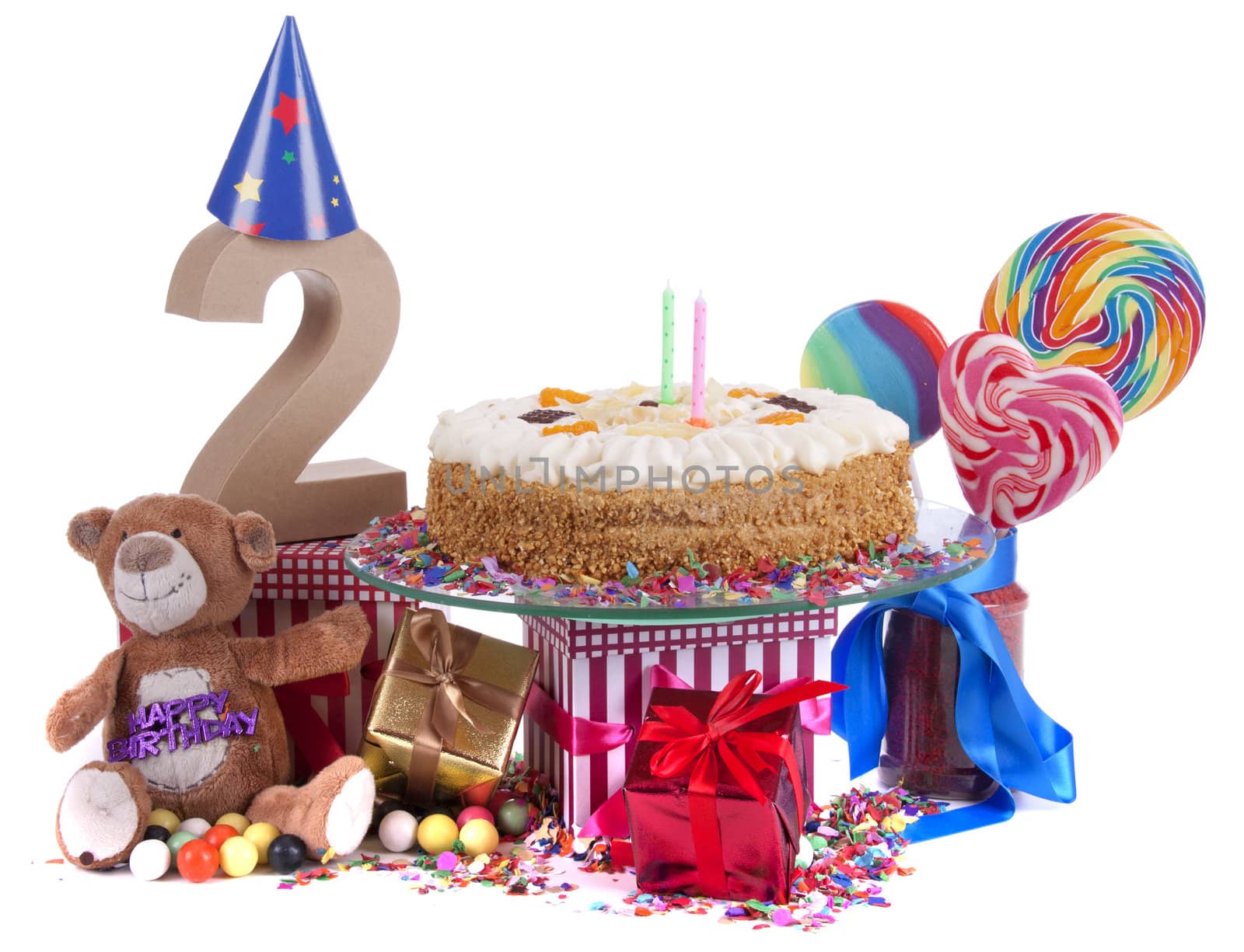 Number of age in a colorful studio setting with paper party hats, a red heart and gifts on a bottom of confetti and sweet cake with candles 