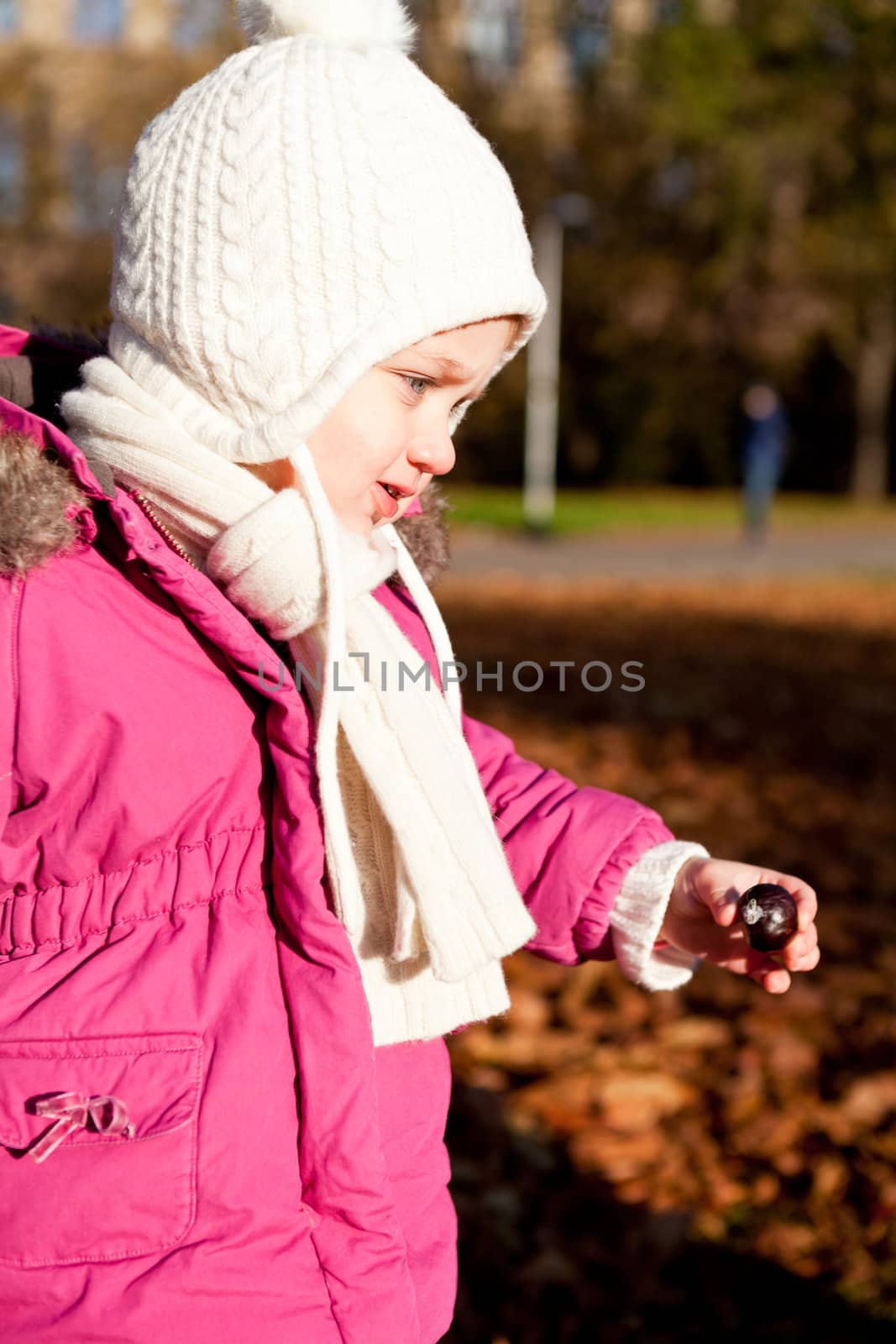 cute littloe girl playing outdoor in colorfull autumn park