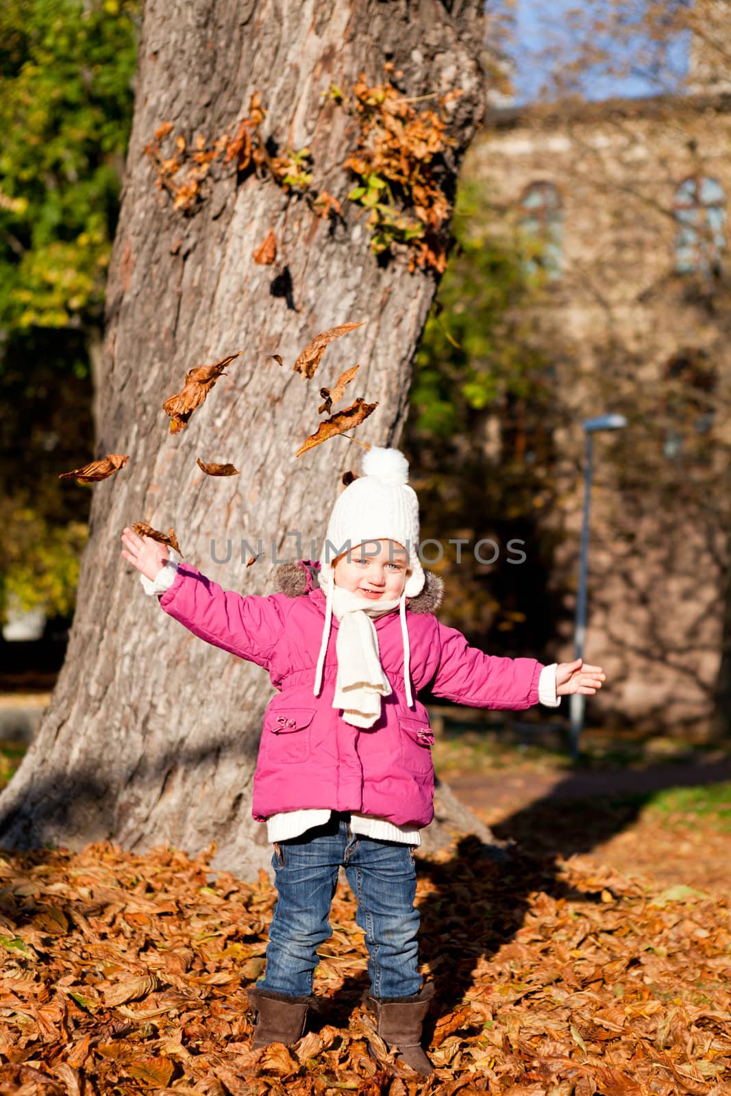 cute littloe girl playing outdoor in colorfull autumn park
