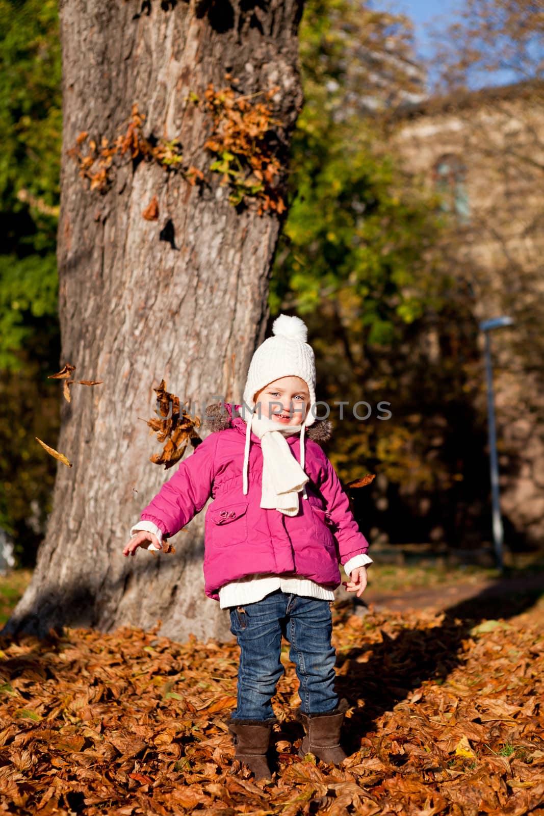 cute littloe girl playing outdoor in colorfull autumn park
