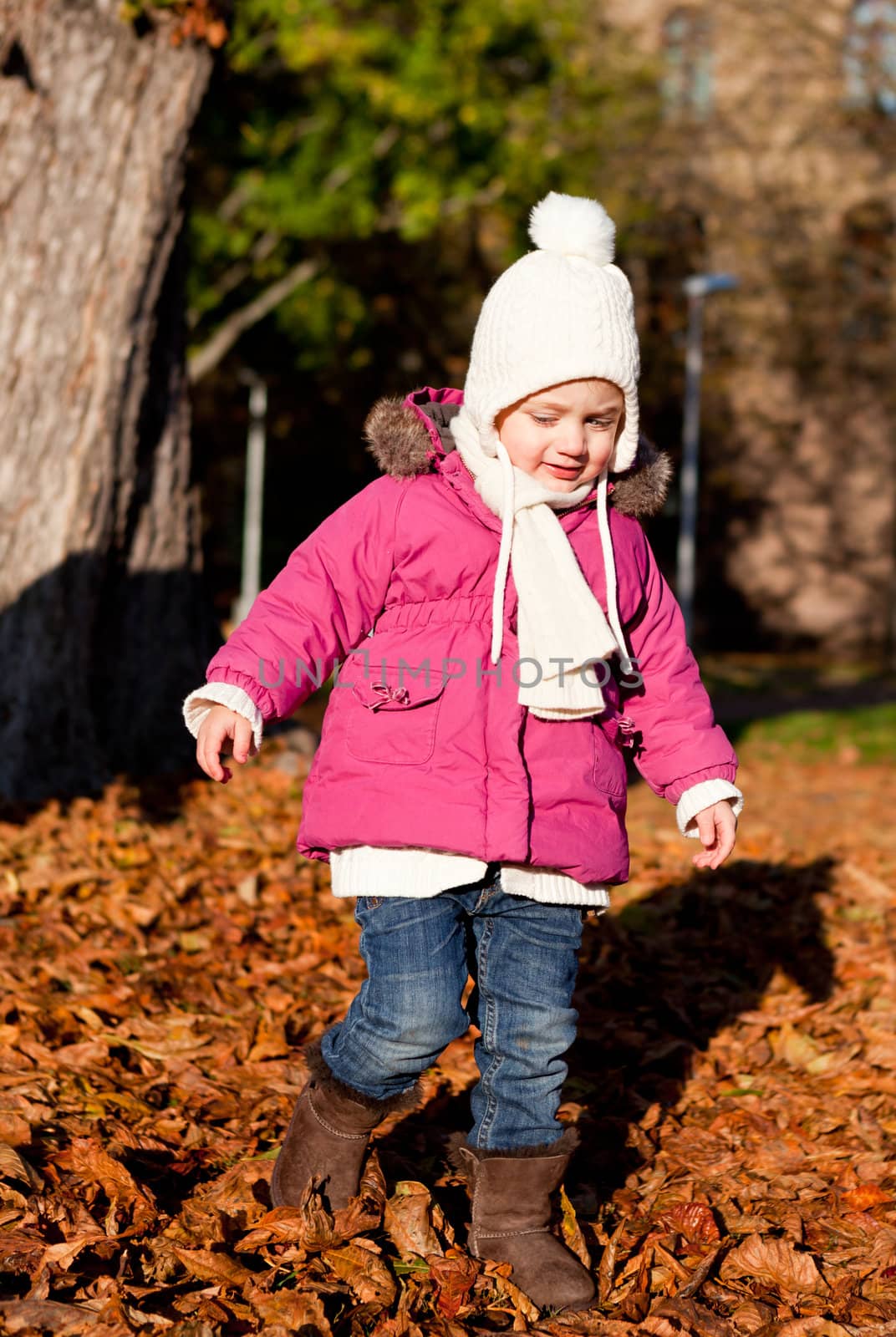 cute littloe girl playing outdoor in colorfull autumn park