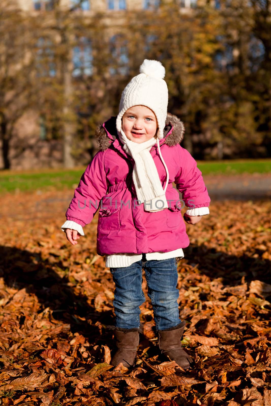 cute littloe girl playing outdoor in colorfull autumn park