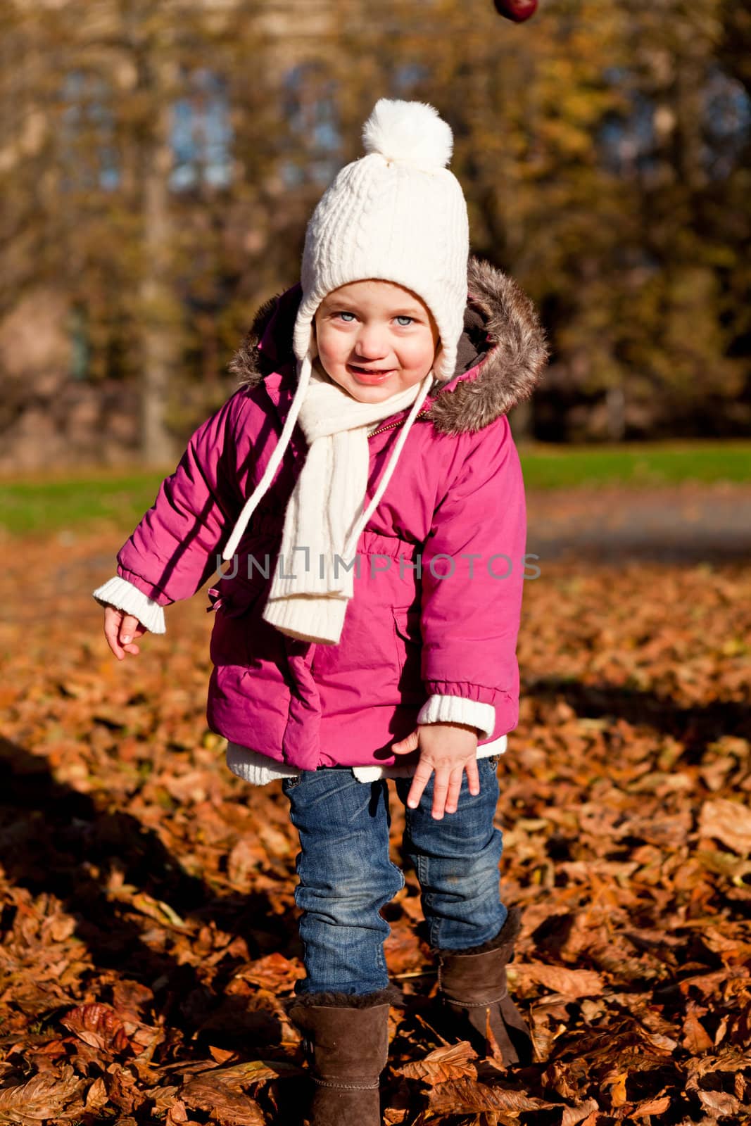 cute littloe girl playing outdoor in colorfull autumn park