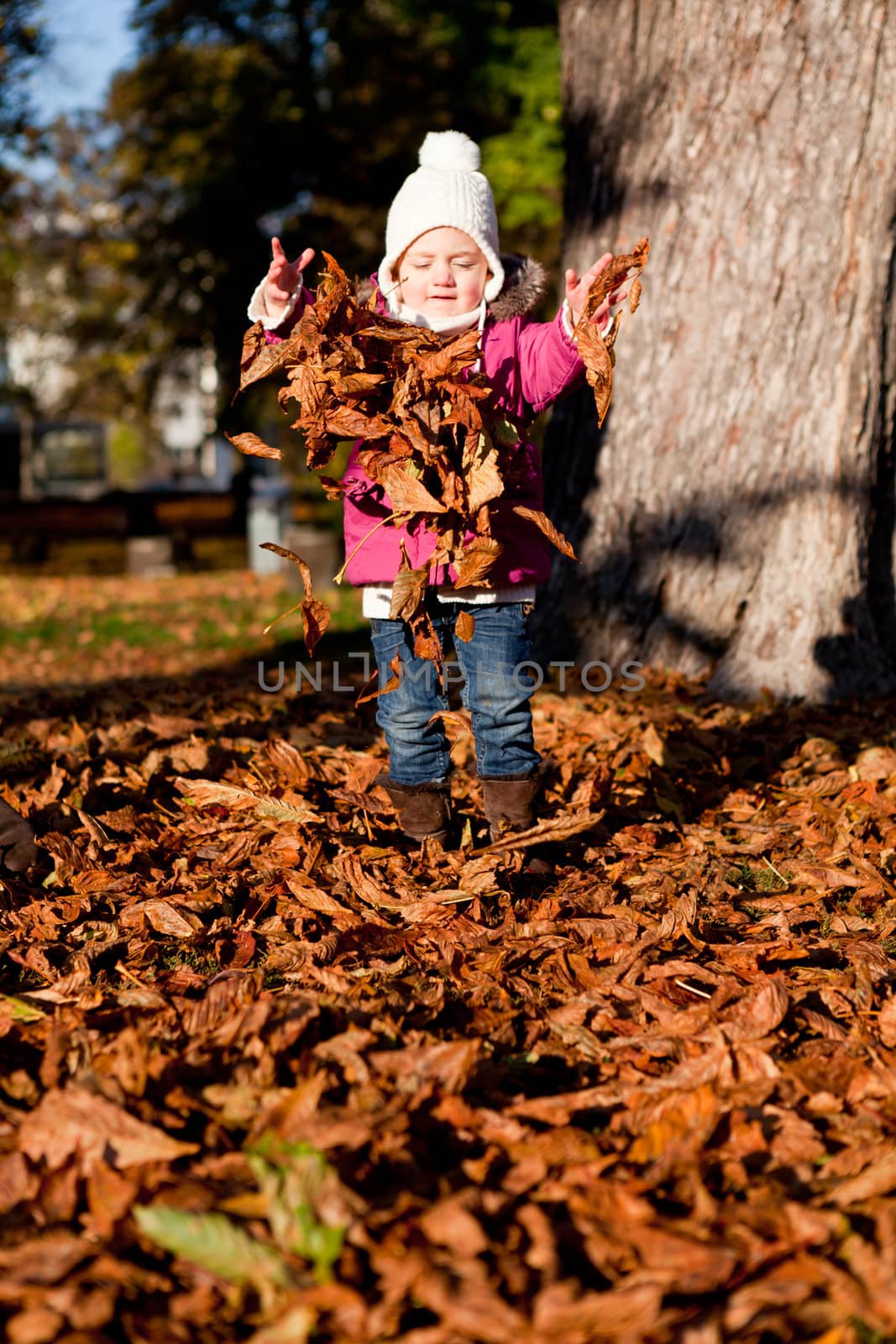 cute littloe girl playing outdoor in colorfull autumn park