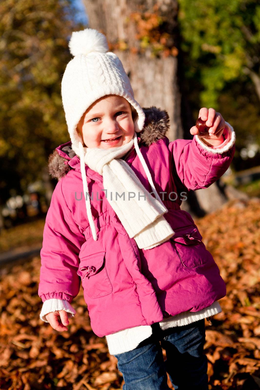 cute littloe girl playing outdoor in colorfull autumn park