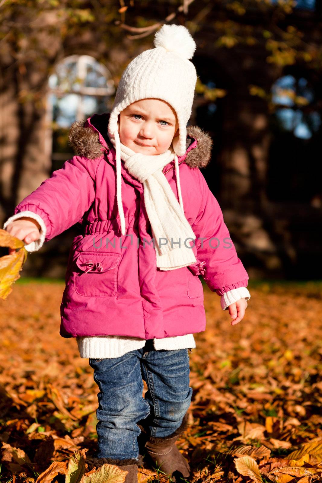 cute littloe girl playing outdoor in colorfull autumn park