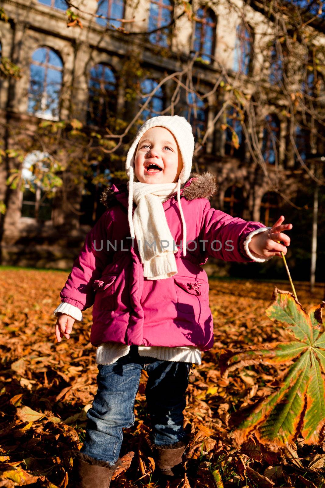 cute littloe girl playing outdoor in colorfull autumn park