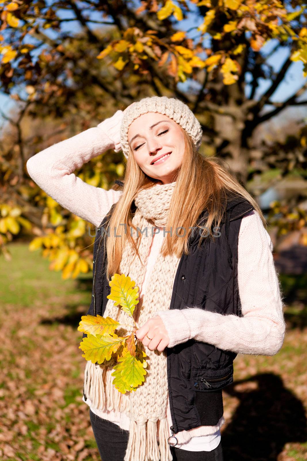 young woman in autumn sunshine outdoor in warm clothes lifestyle