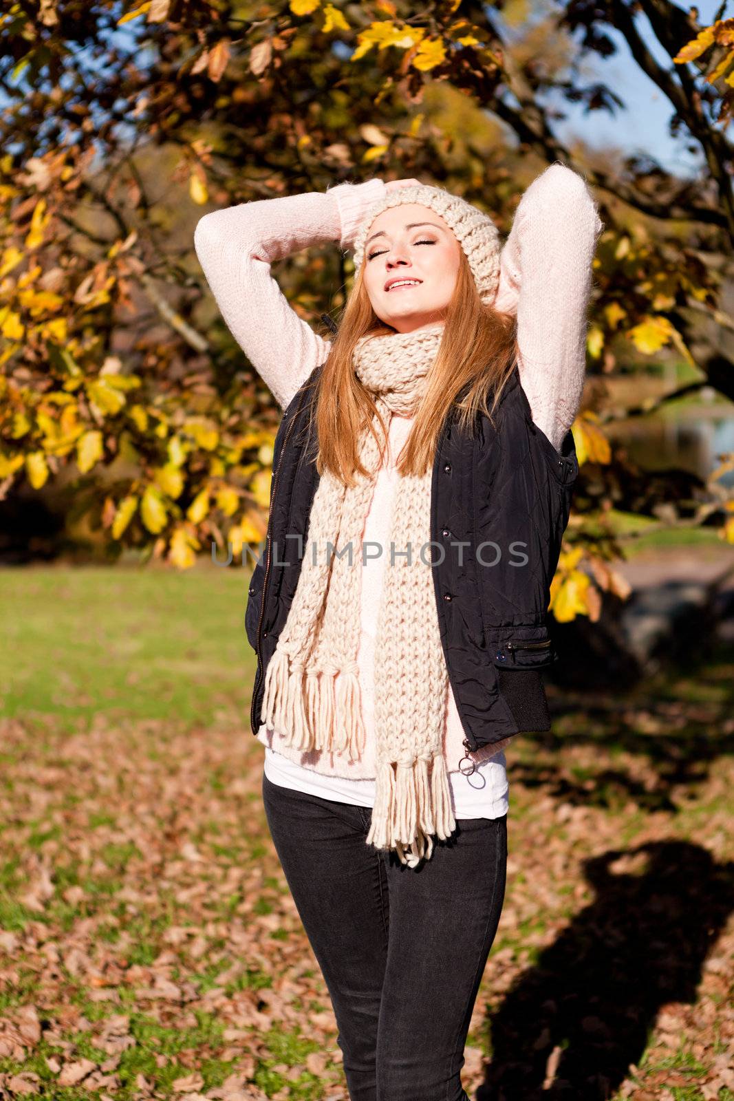 young woman in autumn sunshine outdoor in warm clothes lifestyle