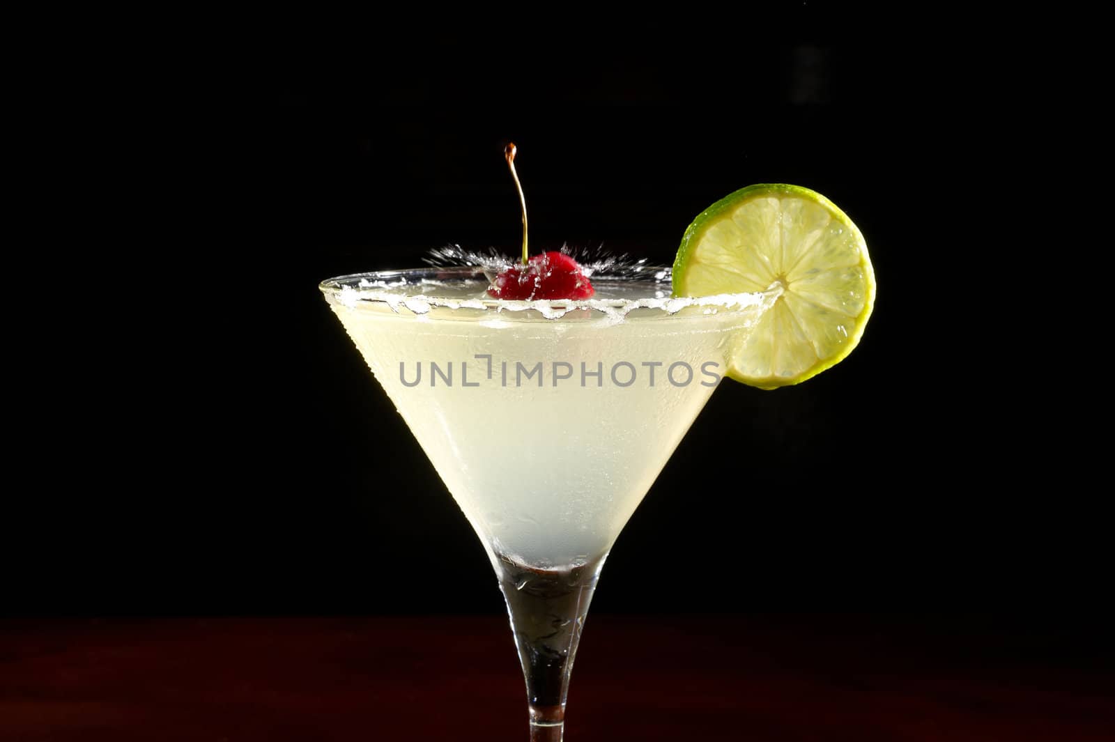 close-up of cocktail with cherry and lemon on a black background