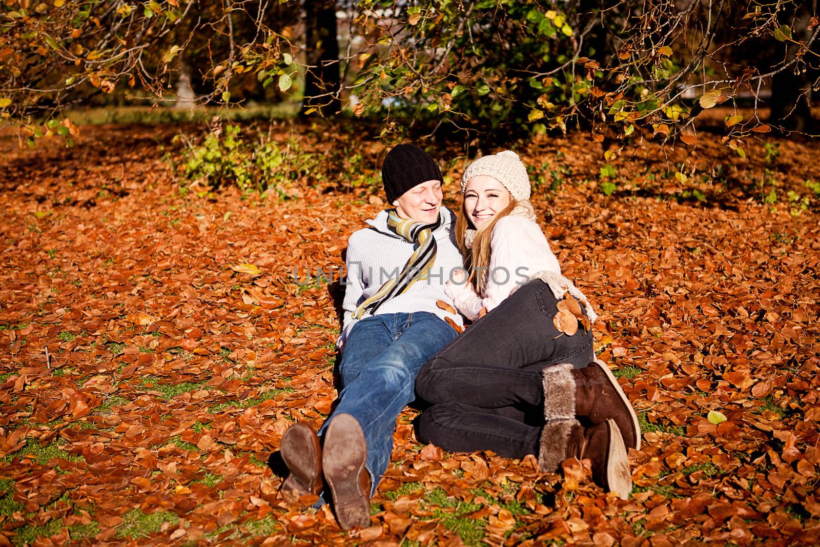 happy young couple smilin in colorful sunny autumn outdoor in park