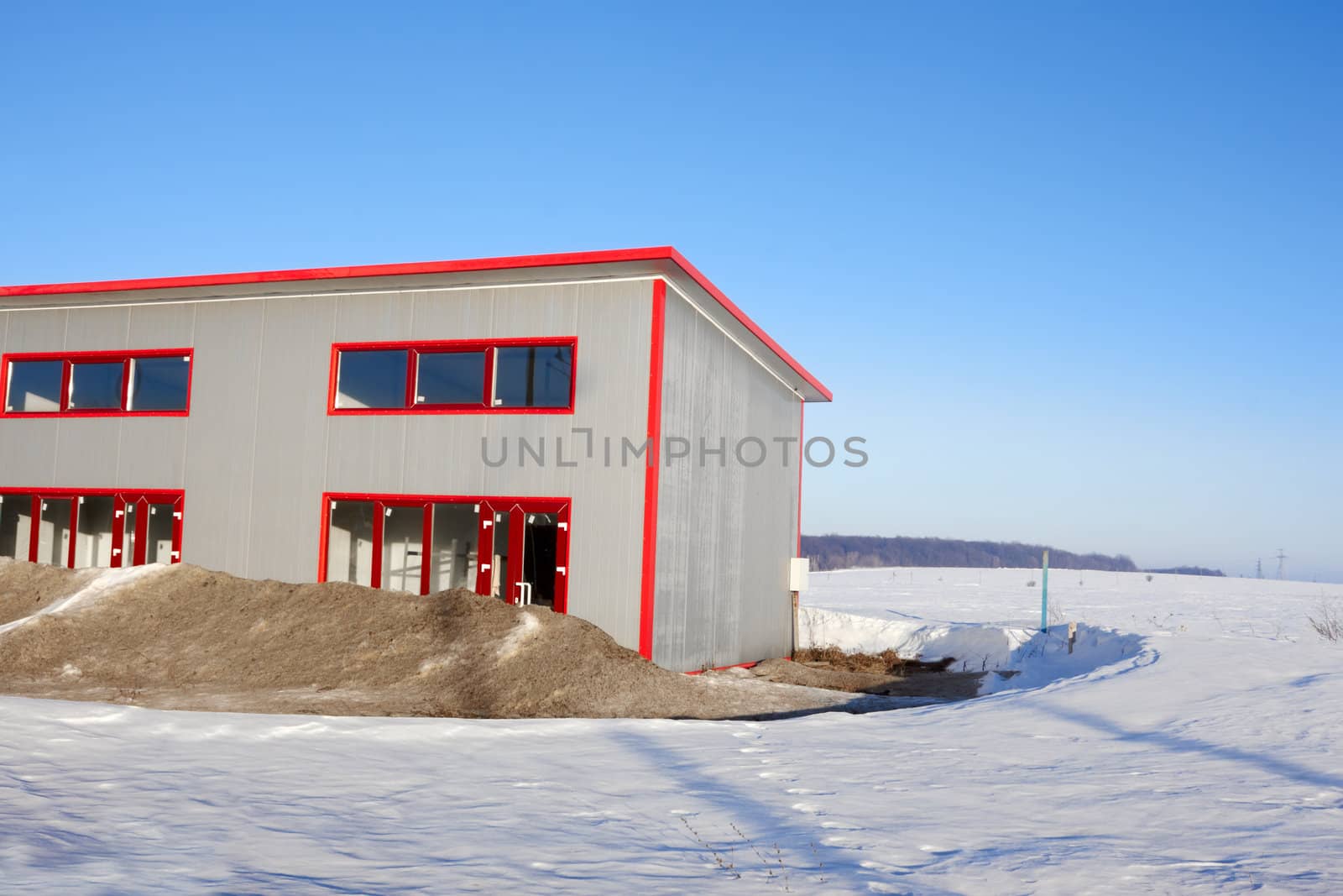 Frozen construction. Unfinished building among the snow-covered field