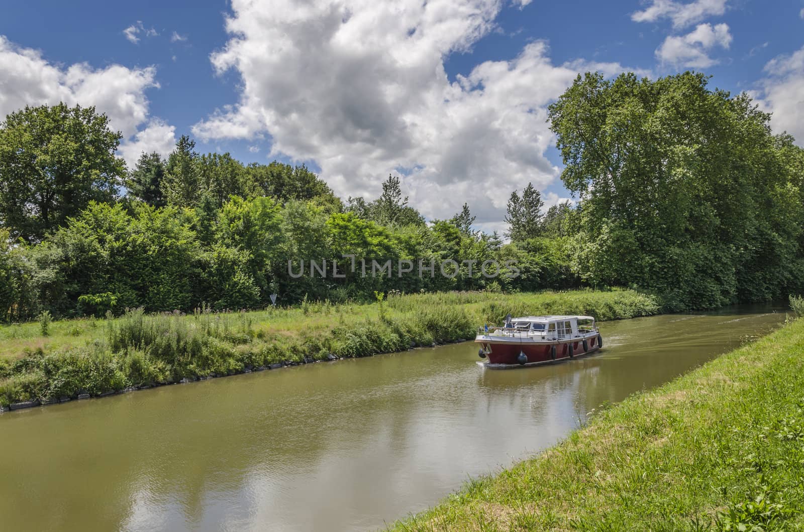 Boat traveling upstream the canal, Burgundy, France.