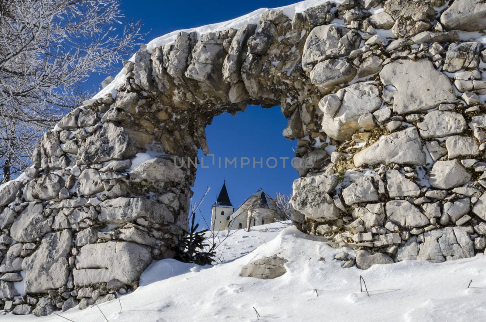 Through ruin view on St. Ursula church on top of the Plesivec mountain, highest elevation church in Slovenia at 1696m above sea level.