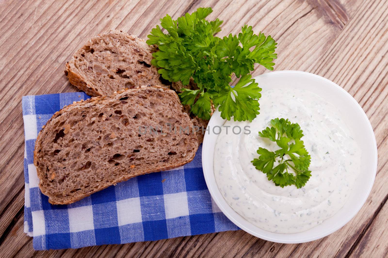 fresh tasty herbal creme cheese and bread on wooden table