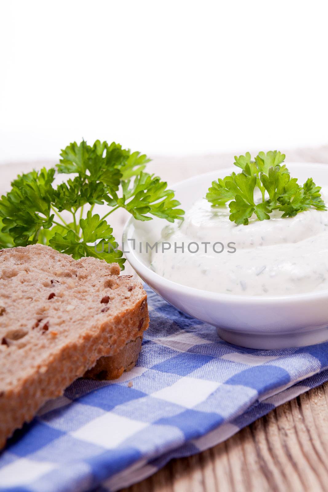 fresh tasty herbal creme cheese and bread on wooden table