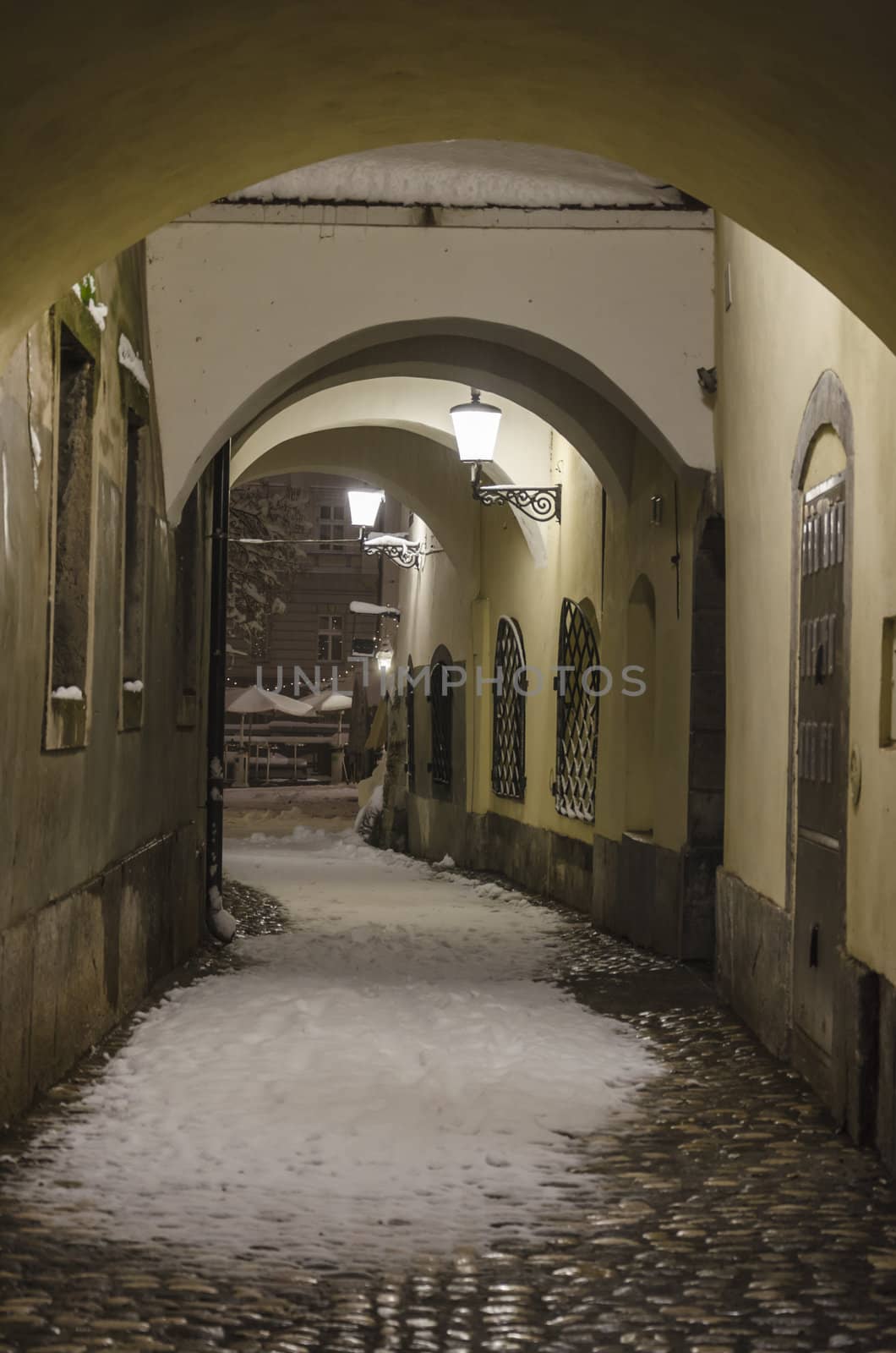 Scenic alley with arches covered with fresh snow, Ljubljana, Slovenia. 