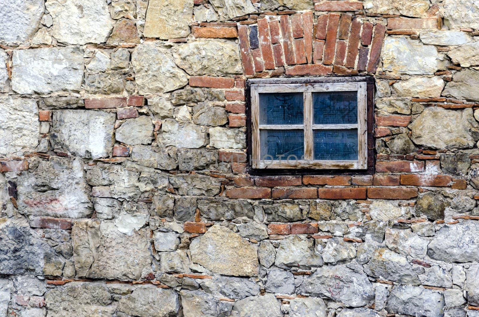 Small window on a stone wall of old house.