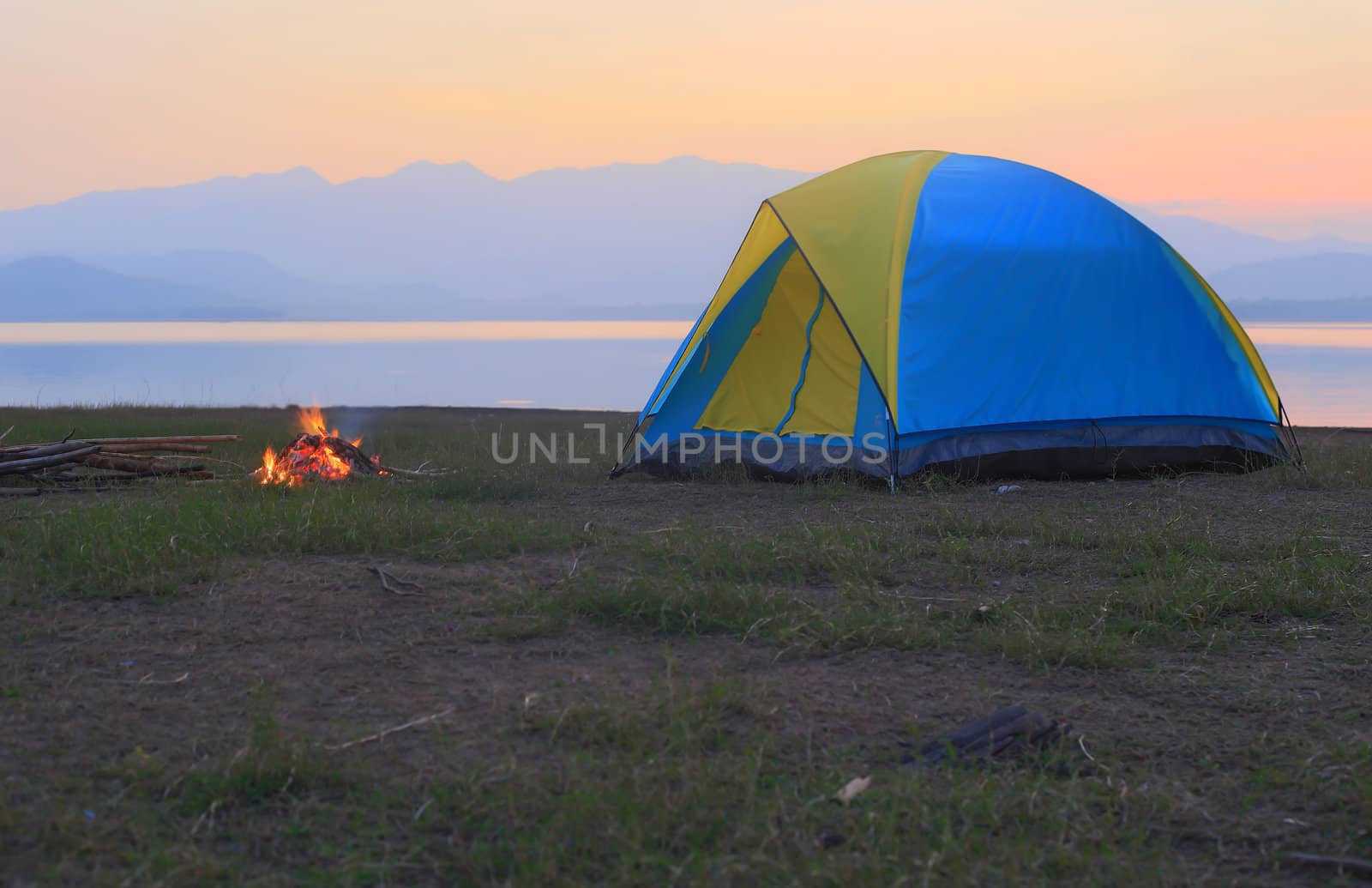 tent and campfire at sunset,beside the lake