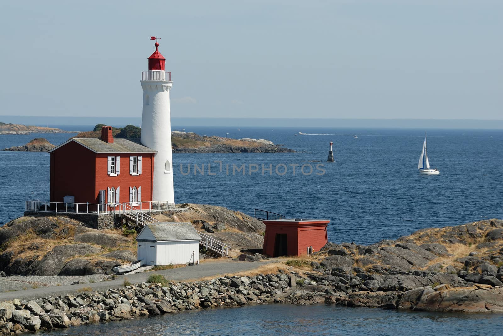 Lighthouse on the rocks on the background of the ocean