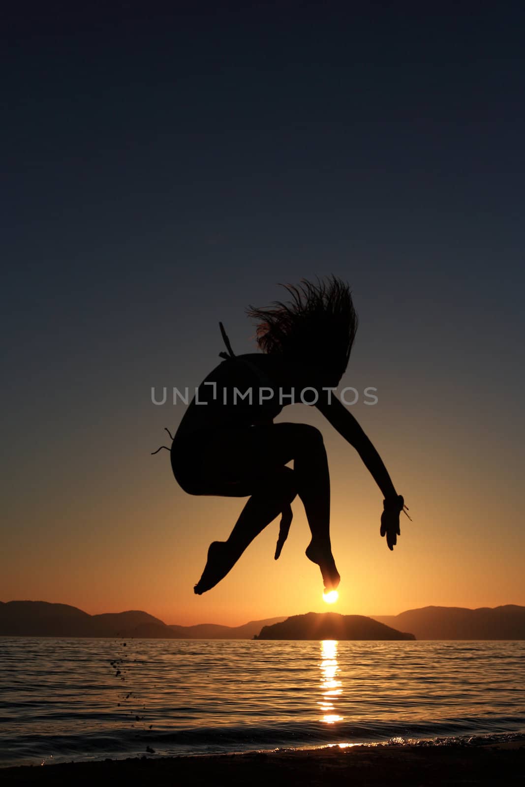 sunset and silhouette of a beautiful dancer in the beach