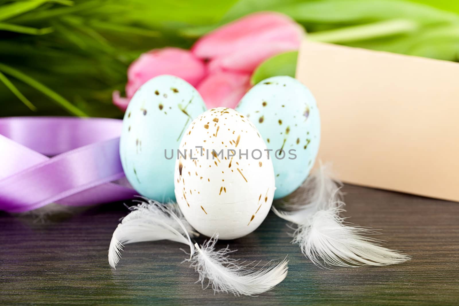 traditional easter egg decoration with tulips and ribbo and feather