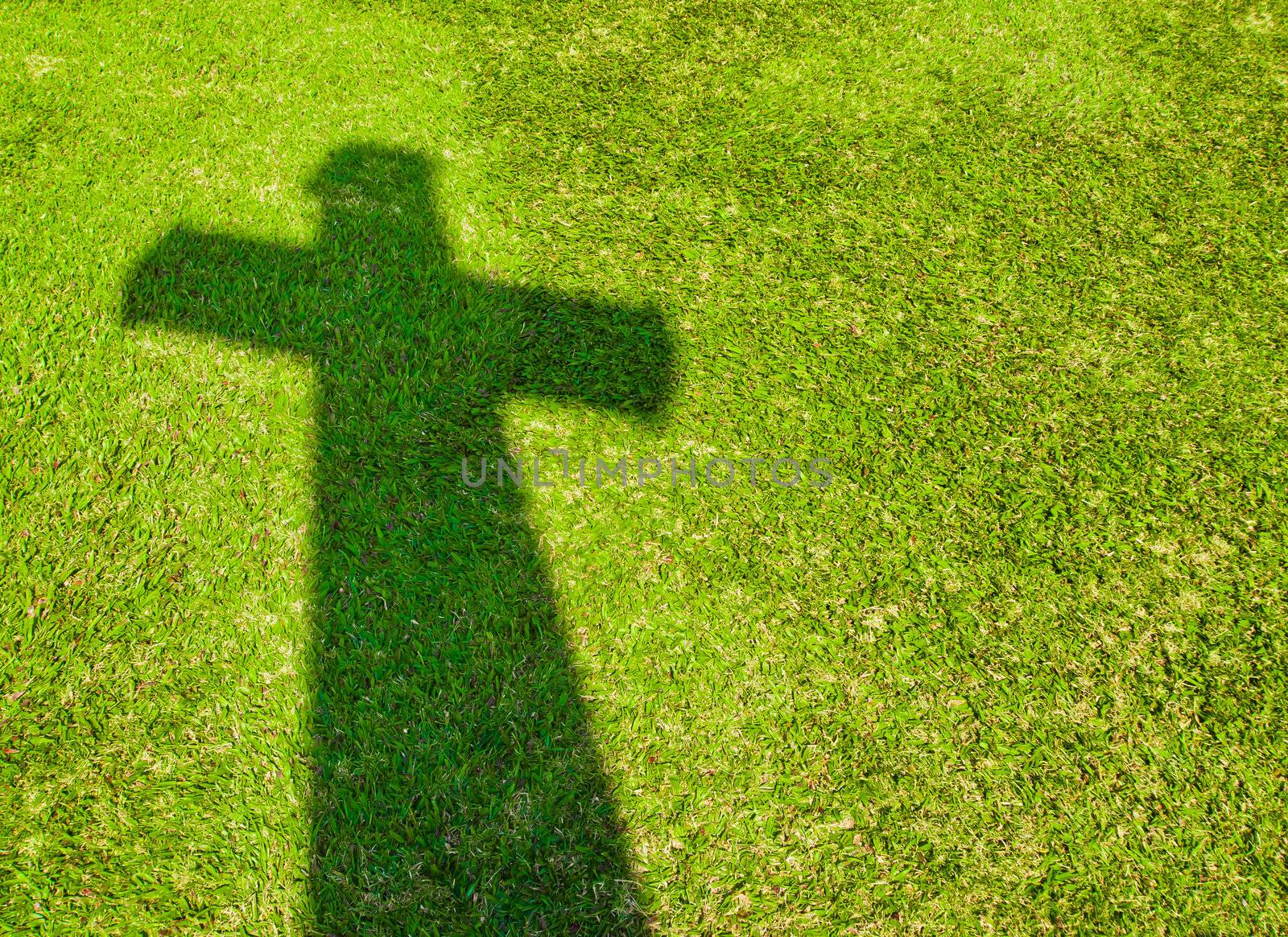 Shadow of Cross on  green grass by gjeerawut