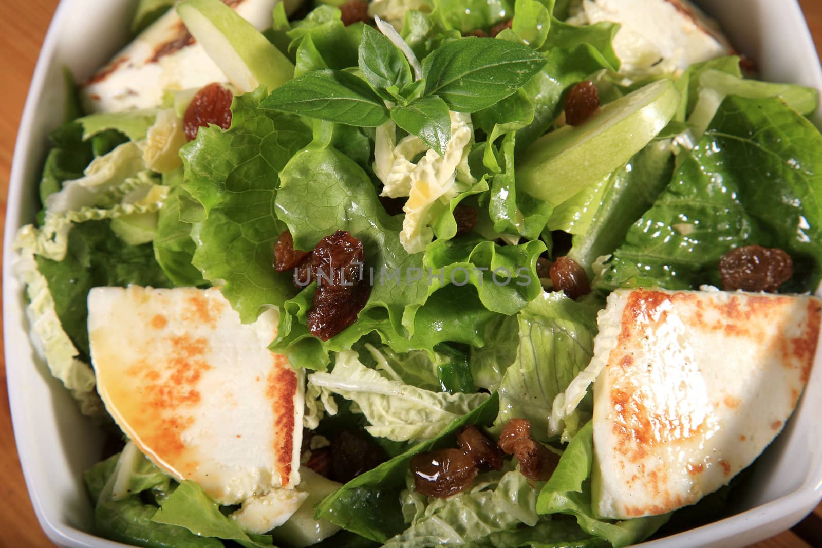 close up of a green salad with cheese and green apple