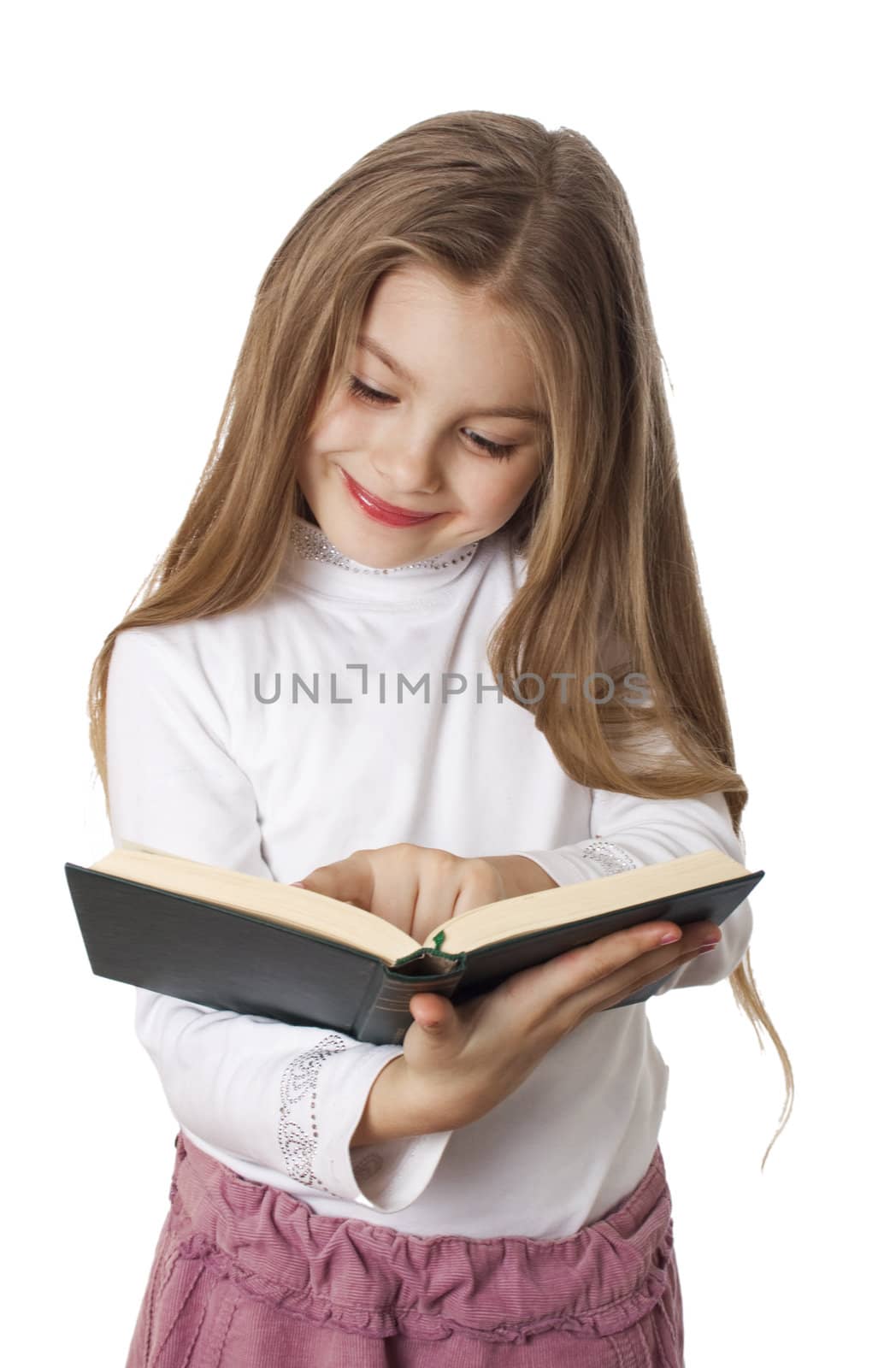 Little girl smiling and reading a book
