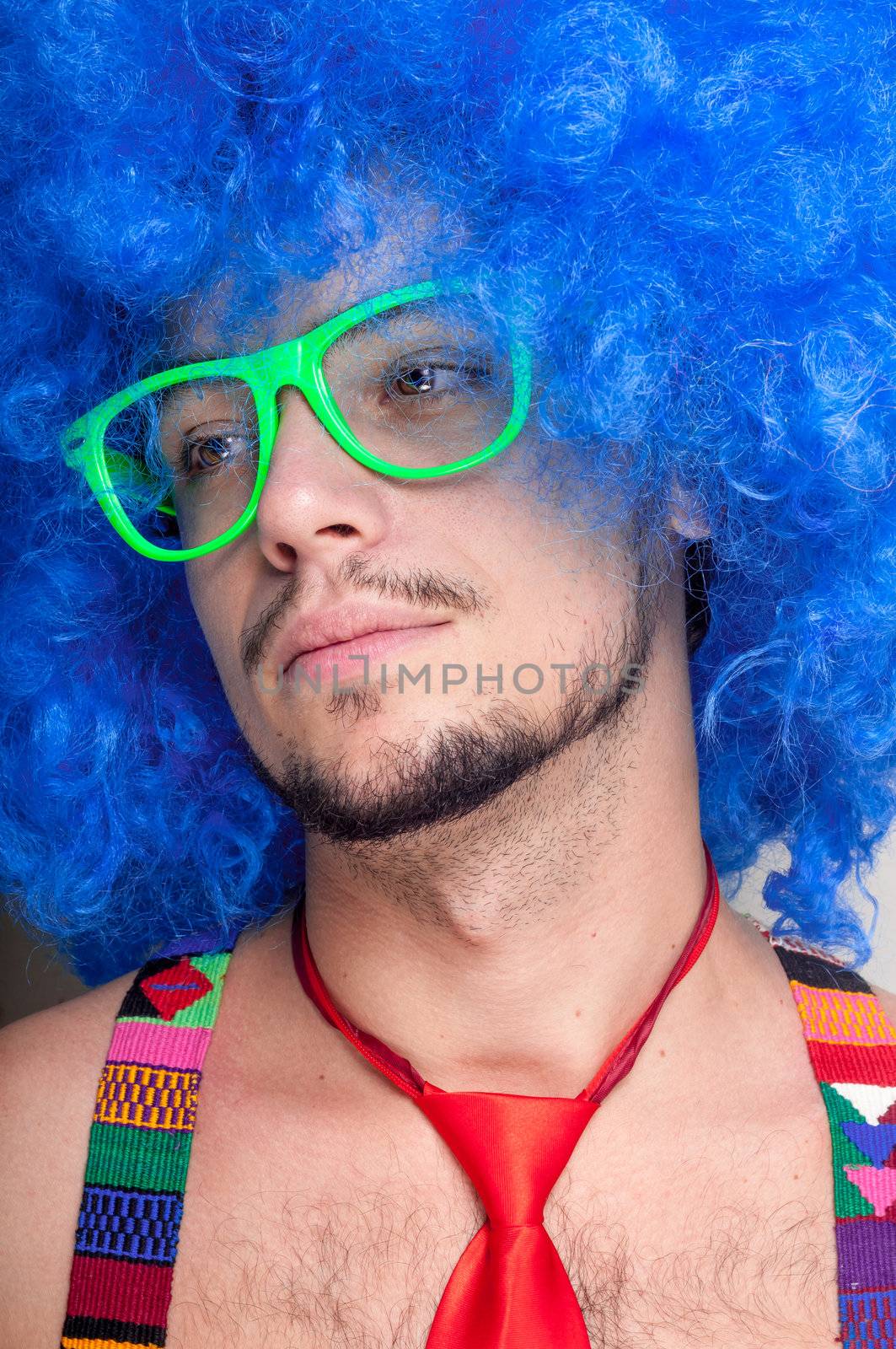 Funny guy naked with blue wig and red tie on green backgrund