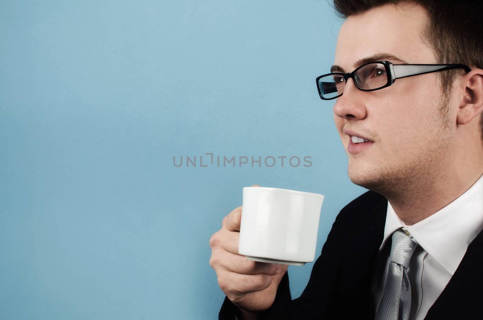 Young businessman making a coffee break and thinks about the future with optimism