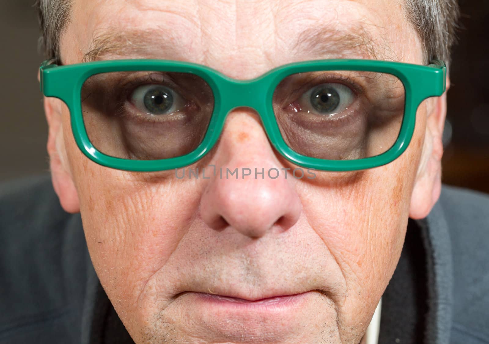 Senior male with shocked expression watching movie in 3d glasses with tight focus on face and eyes