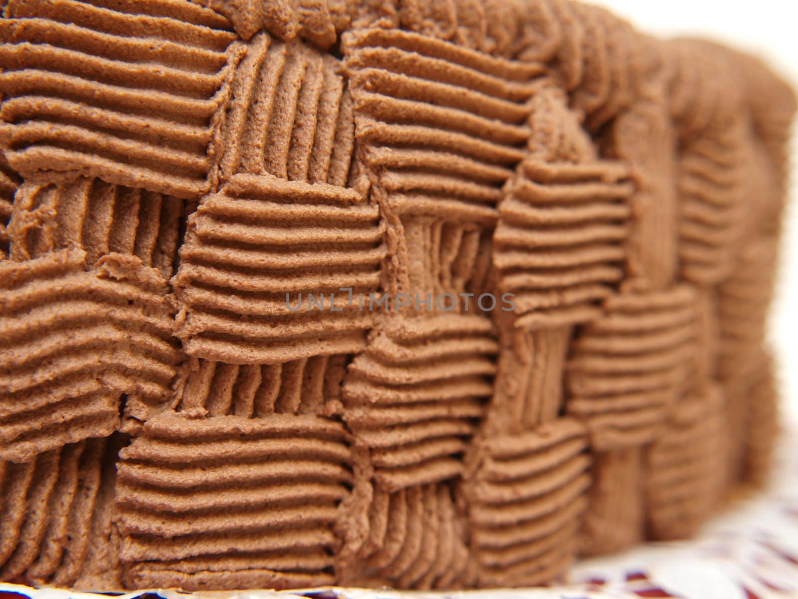 Closeup view of a chocolate cream pattern, around the cake by Arvebettum