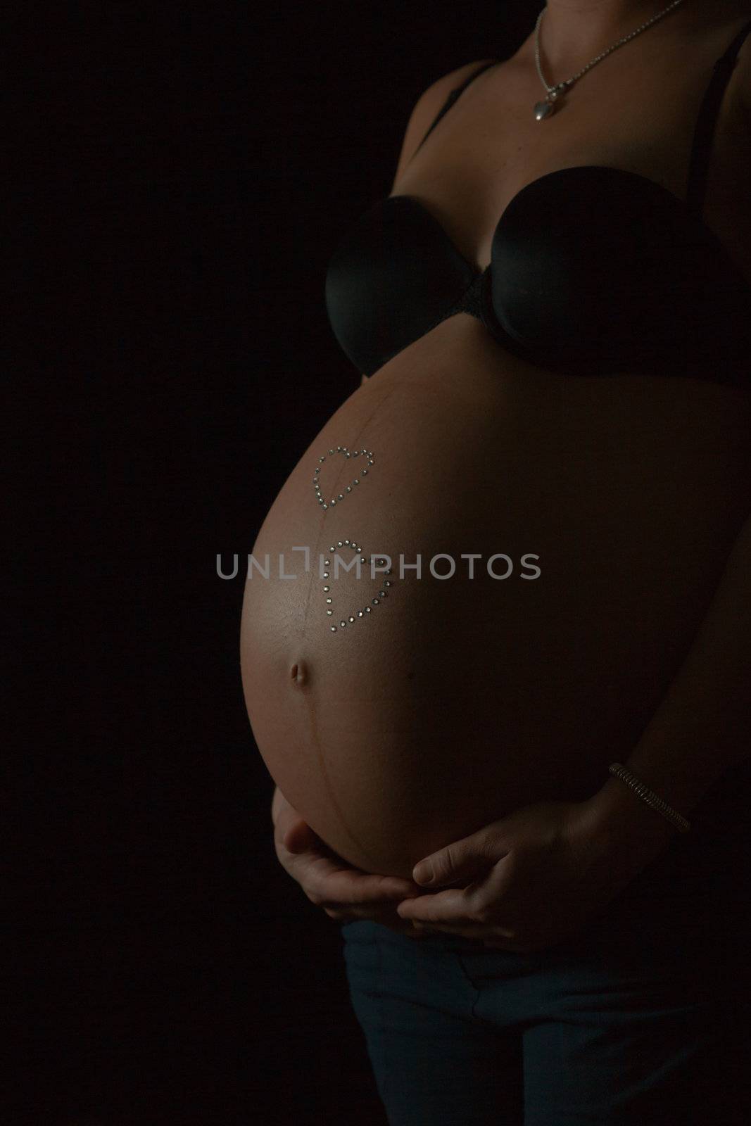 Black-white image of the belly of a pregnancy woman (isolated on black)