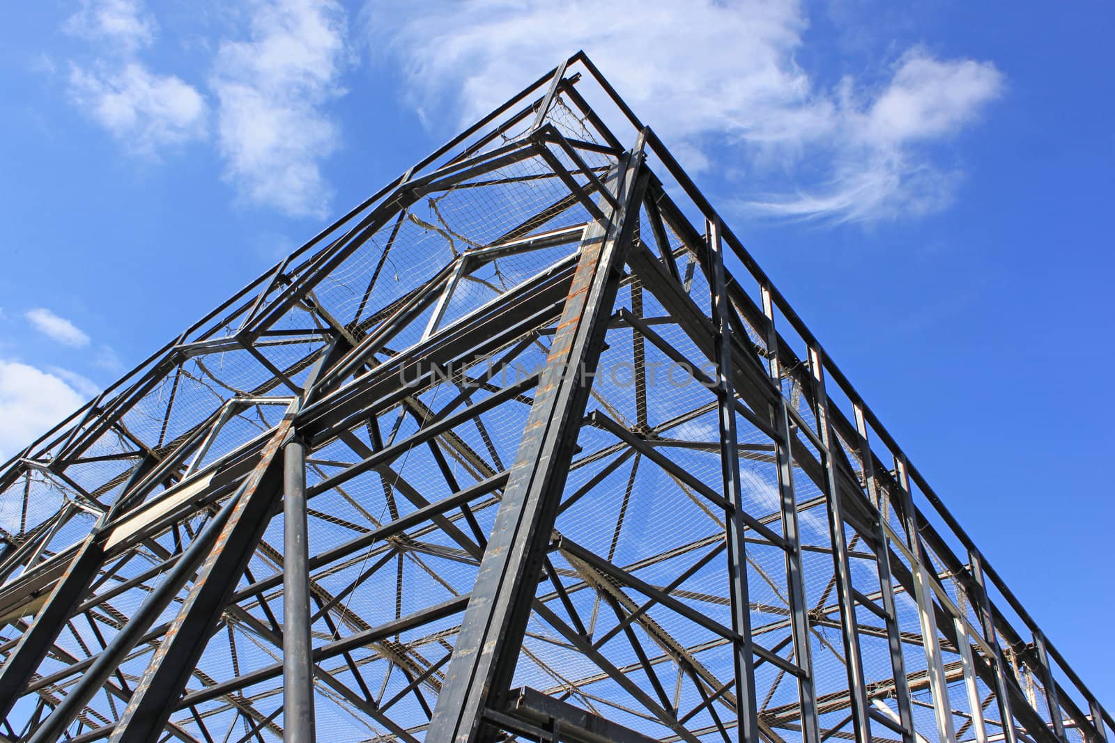 a metal frame with safety net against a background of blue sky with clouds
