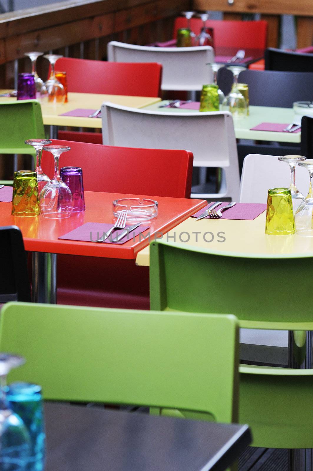 colored tables and chairs on a restaurant terrrace