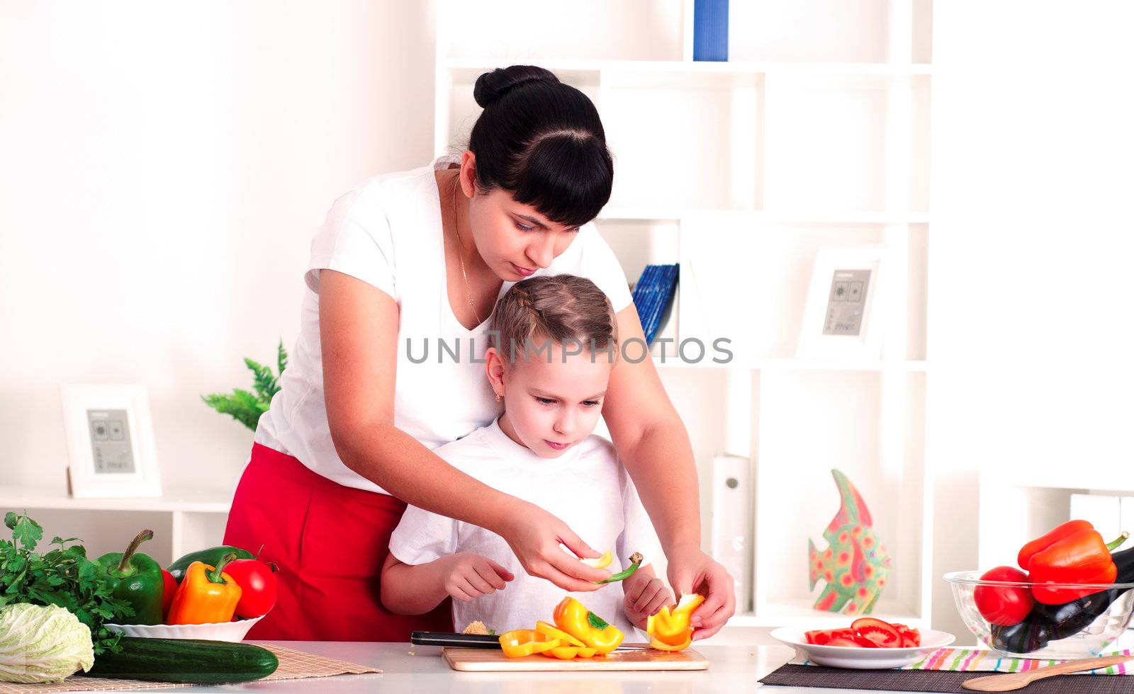 Mother and daughter cooking vegetable salad together