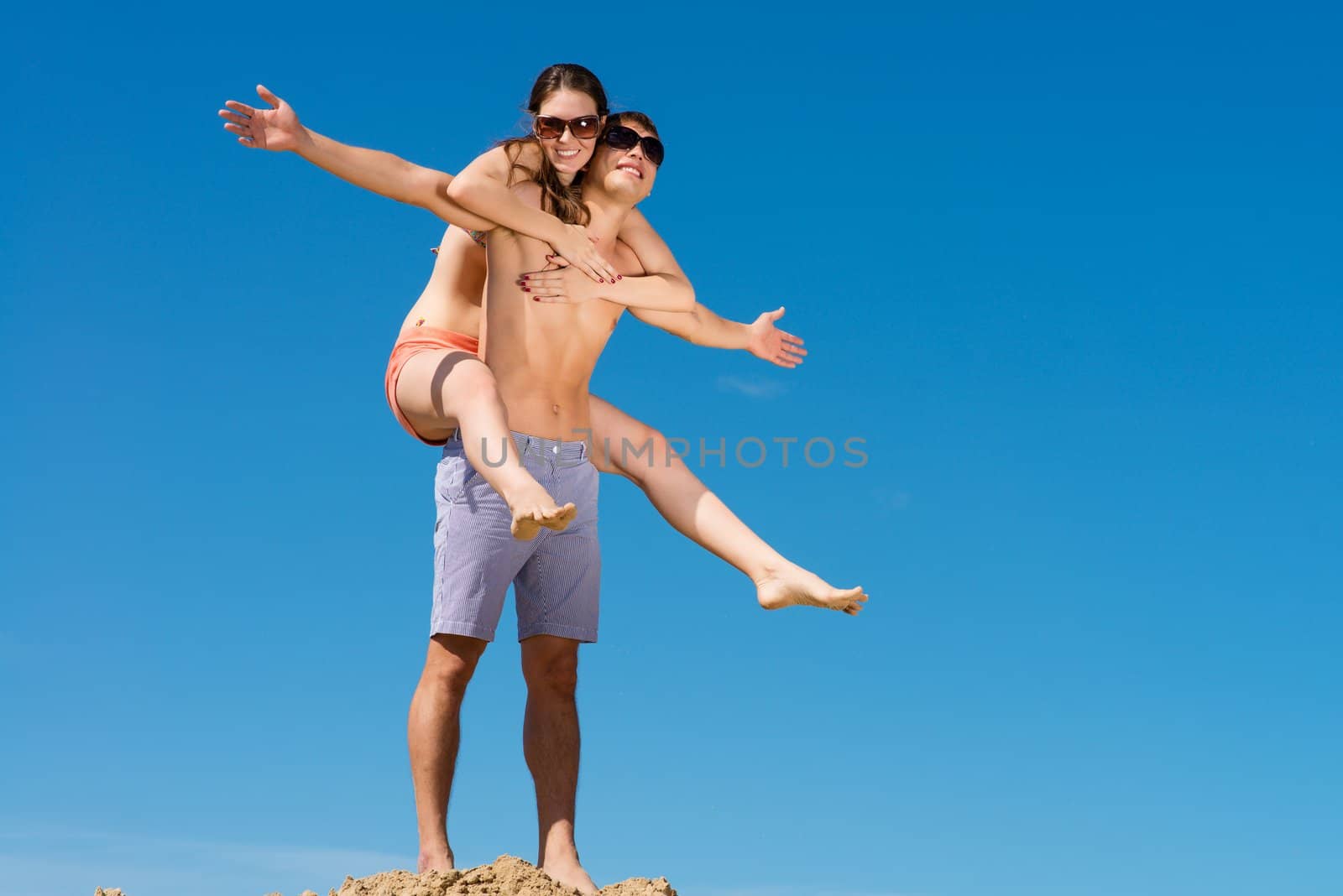 Young couple hugging on a background of blue sky, hold together honeymoon