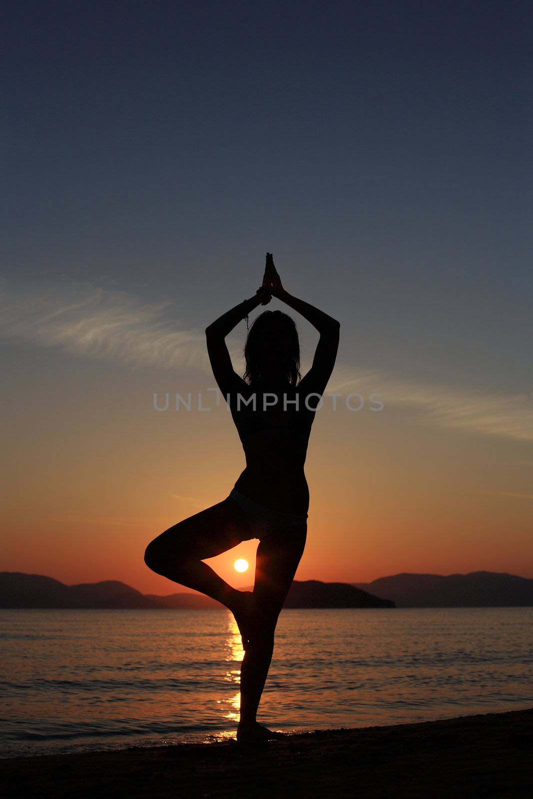 silhouette of a girl dancing in the beach with a beautiful sunset as a background