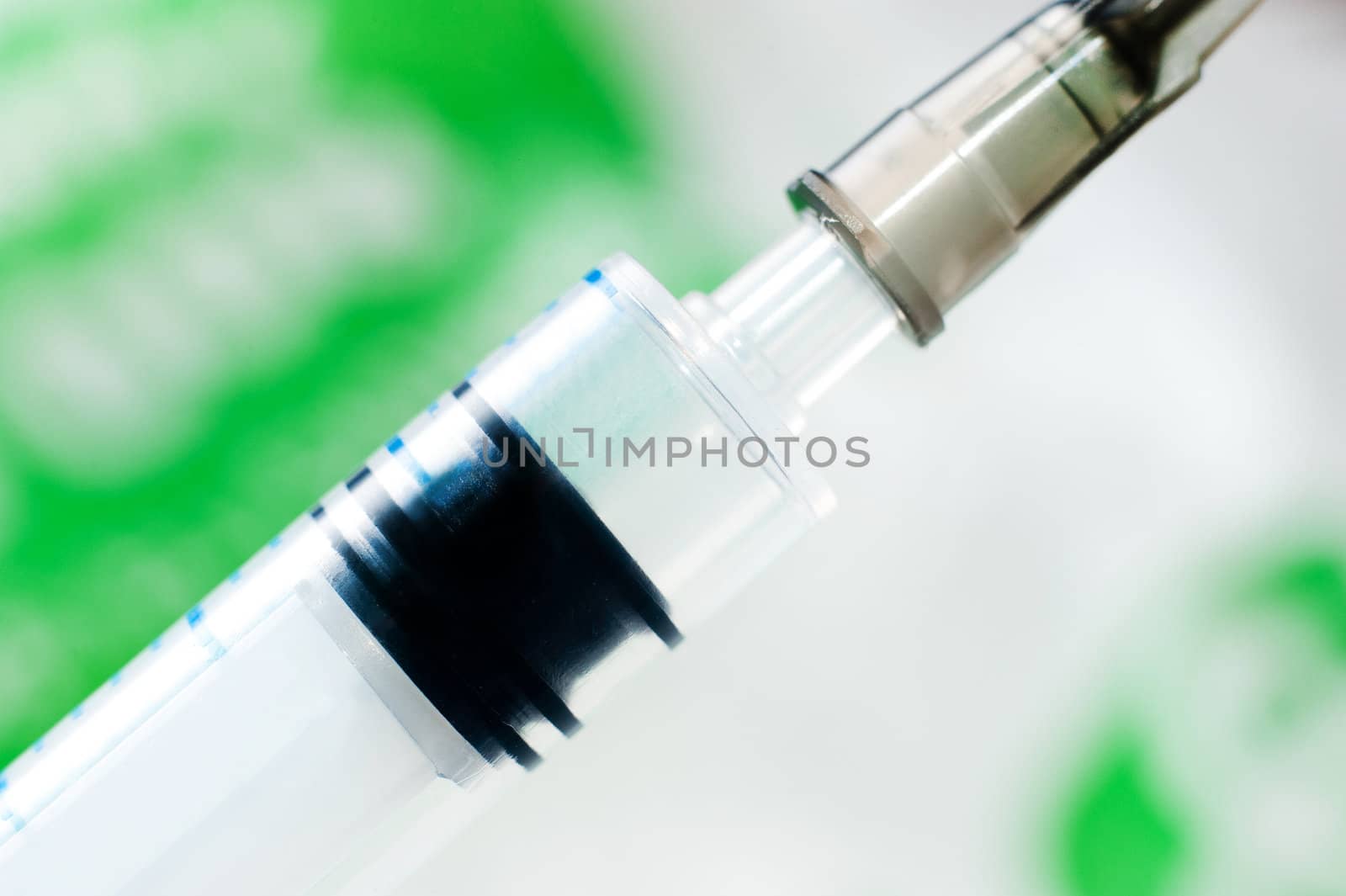 Syringe with needle on blur green background