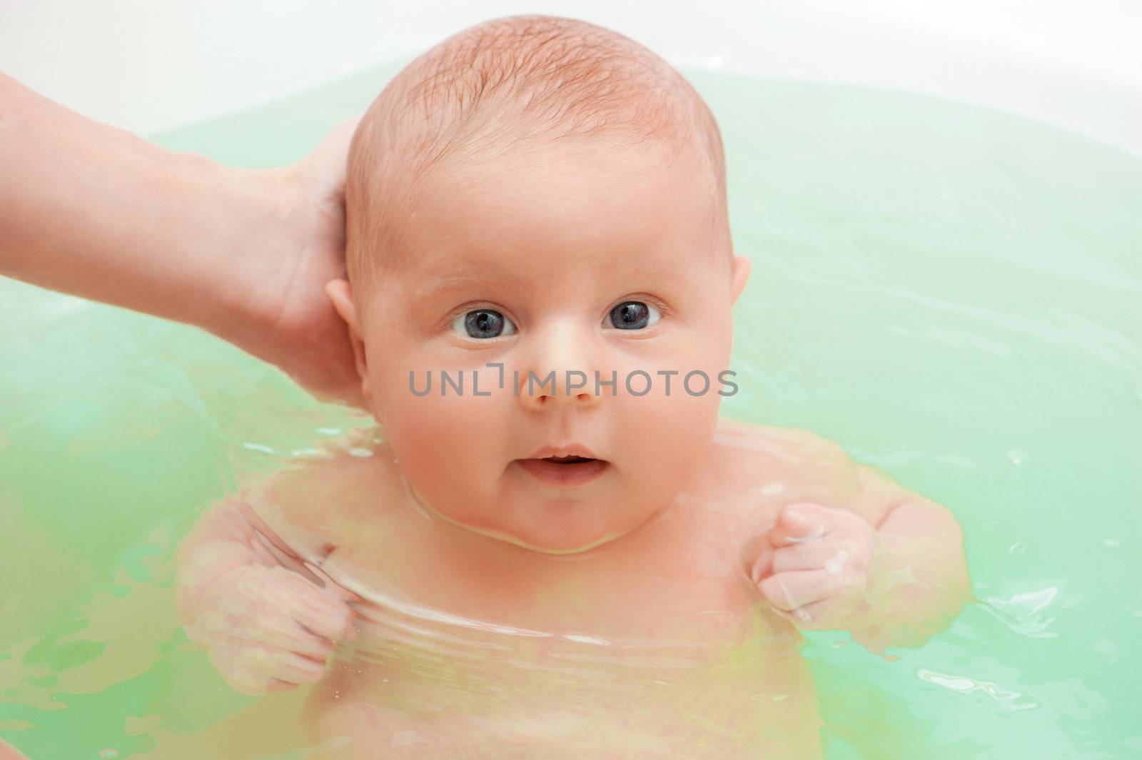 Cute baby swimming in the blue water