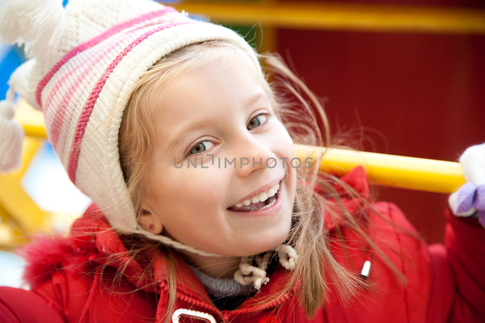 Smiling face of little girl on outdoor playground