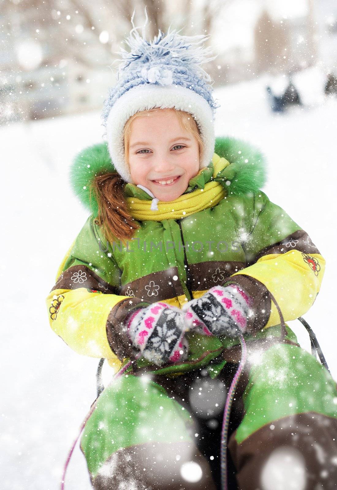 Happy child on sledge in winter