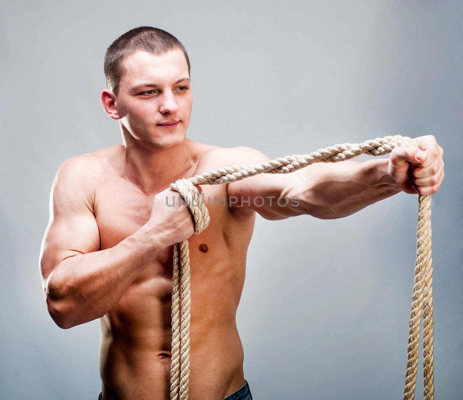 Attractive muscular man rope breaks