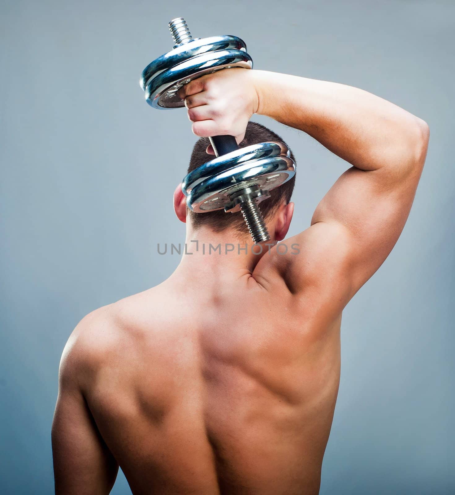 back attractive muscular man with dumbbells