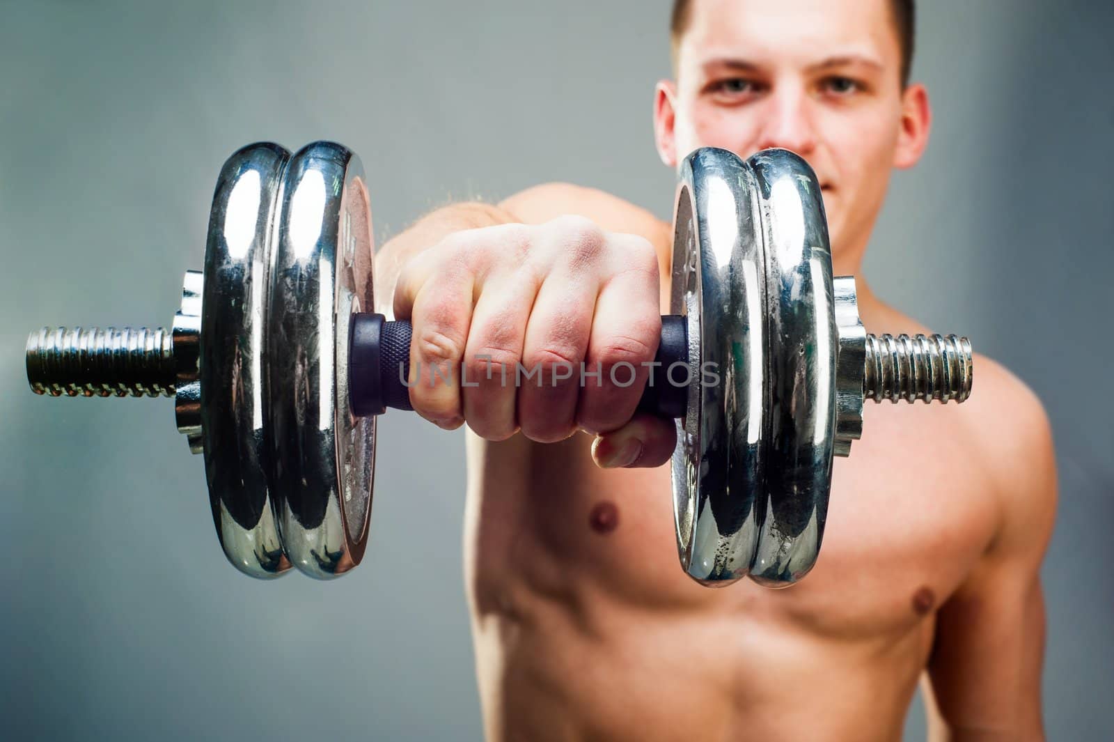 handsome man holding a dumbbell in front