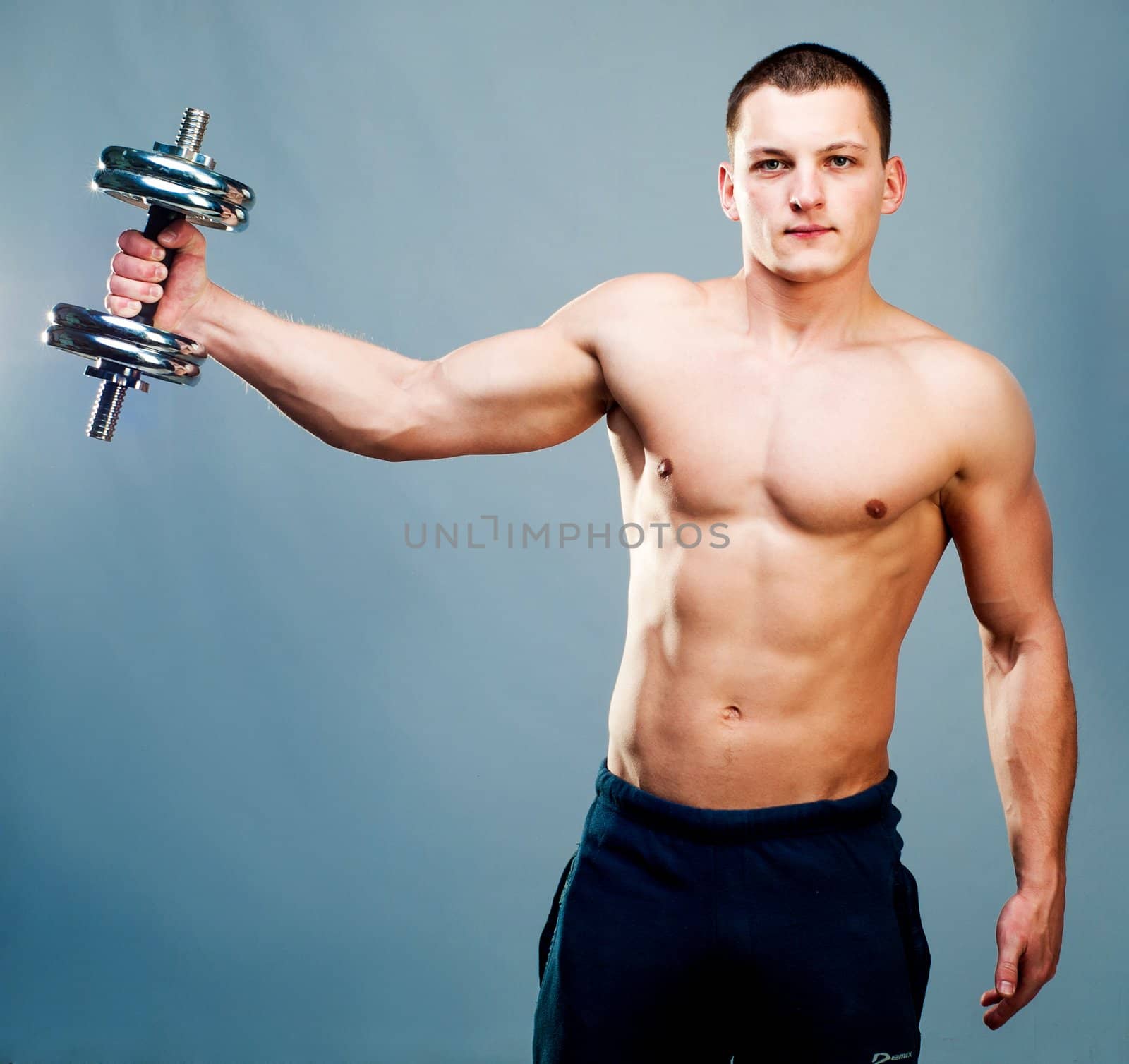 attractive athletic man with dumbbells in hand