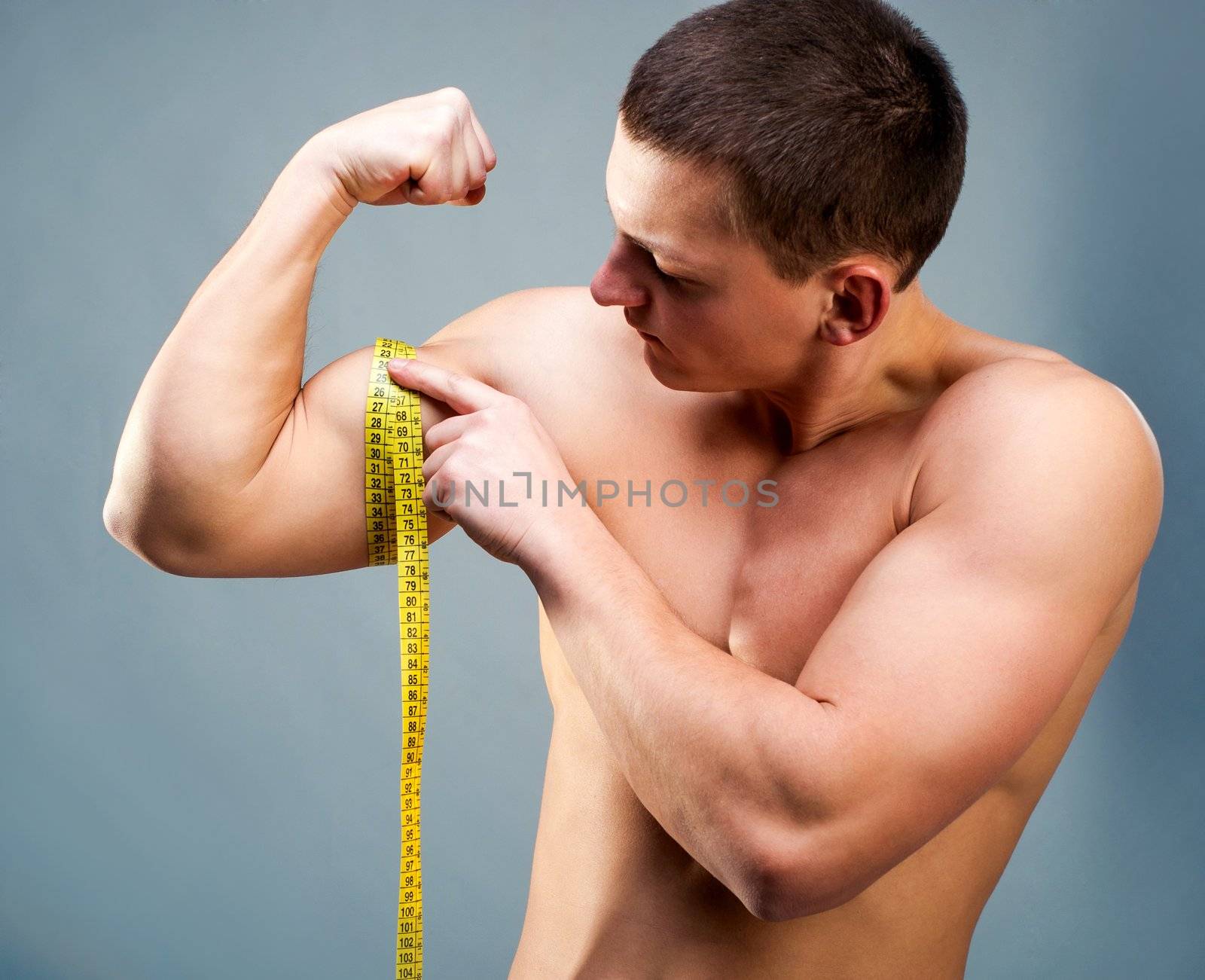 attractive athletic man measuring his biceps