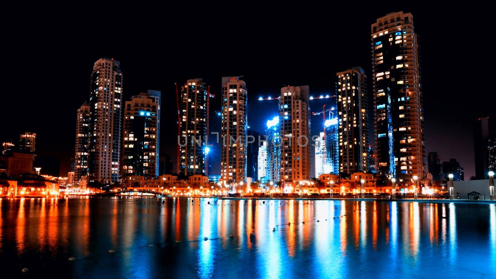 Colorful night view of city of Dubai with modern downtown buildings